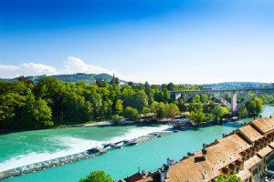 Aare river in Bern with dam and bridge behind the red houses roofs